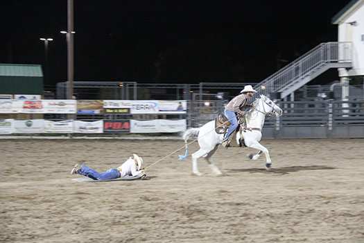 Woman pulled by horse on a cowhide in Family Rodeo