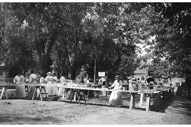 ladies-prepairing-apple-pie Ladies prepairing Apple Pie Day celebrtion on East Third Street just east of East Ave. Circa 1912