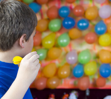 cowboy-cove-darts kid throwing dart at balloons